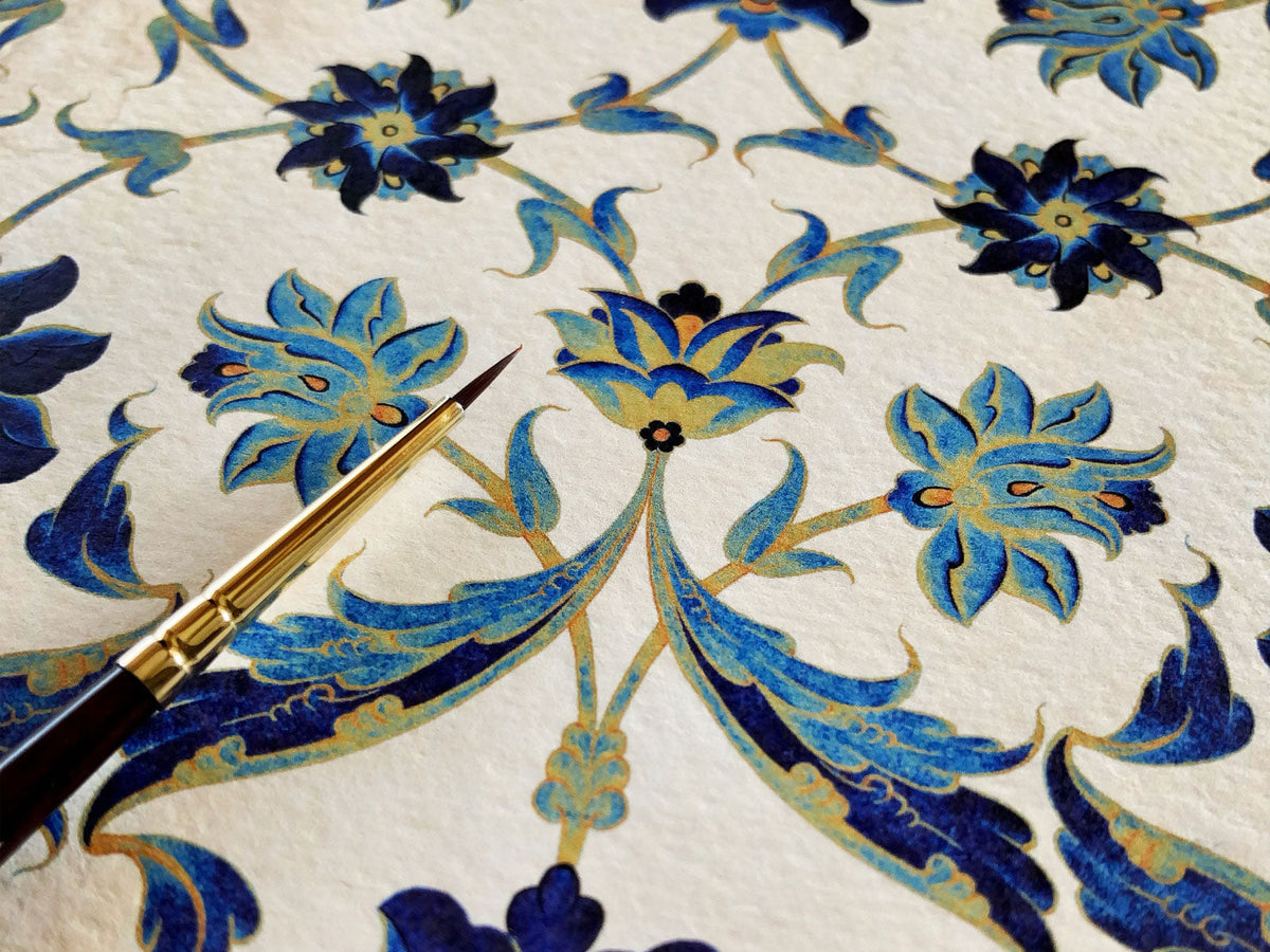 Ornate elegant gold and blue floral design with paintbrush lying atop