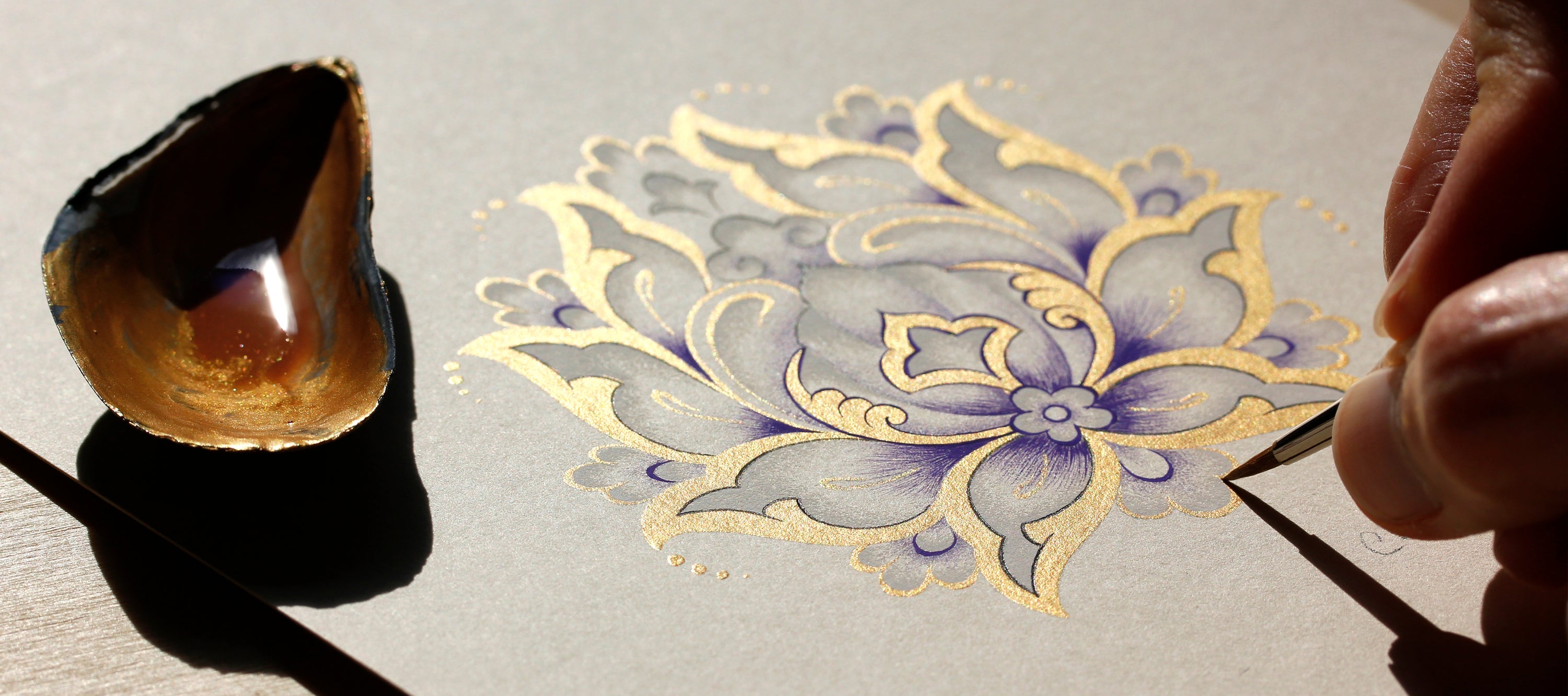 Close up hand painting floral motif gold paint